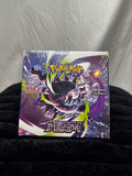 A sealed Pokémon TCG booster pack featuring a large purple and black creature illustration with green accents, photographed on a black fabric surface against a wrinkled light gray backdrop.